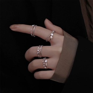 Detailed view of silver stackable rings set featuring pearls and geometric star patterns