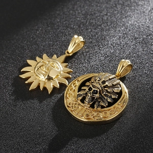 Detailed view of golden Indian chief skull and sun face pendants on black background