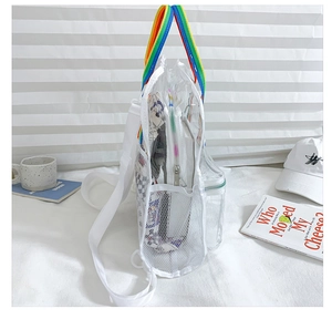 Detail of transparent PVC backpack showing rainbow handle and white mesh side pocket