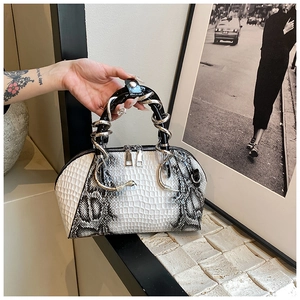 Detail of stone pattern shell bag with unique snake-shaped metal handle and zipper