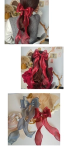 Close-up of large iridescent organza bow hair clip with long flowing ribbons