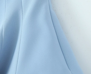 Macro shot of light blue fabric detail with fine vertical stitching and plain weave texture