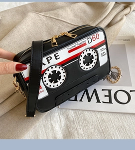 Detail of vintage cassette cross-body bag with gold dual zippers and chain strap