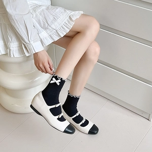Detail of black JK socks with white bows and frill cuffs paired with Mary Jane shoes