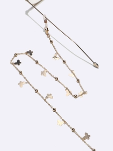 Detail of golden glasses chain with tiny metal beads and flat butterfly pendants