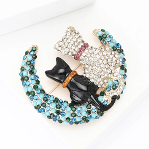 Detail of crystal cat brooch with blue and green rhinestones on a crescent moon design