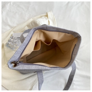 Interior view of grey fabric tote bag showing khaki lining and functional pockets