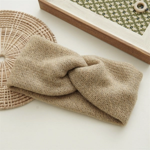 Close-up of khaki knitted twist headband with textured ribbed wool pattern for winter