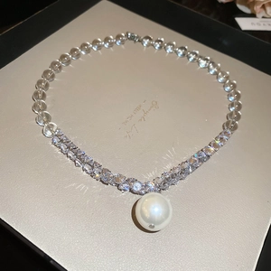 Detail of beaded necklace with crystal beads and a large pearl pendant in a gift box