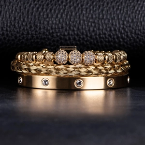 Close-up of golden stainless steel bracelet set with diamonds on black leather background
