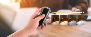 Detail showing hand holding foldable black book light with four brightness levels
