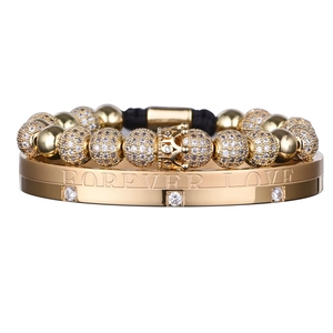 Detail of stacked gold crown bead bracelet and Forever Love engraved crystal bangle