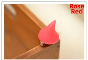 Detail of rose red little devil horn hair clip with metal duckbill clip on wooden box