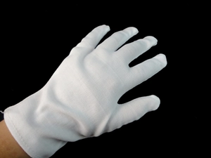 Close-up of white cotton performance gloves with fine texture for magician and clown costumes