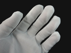 Close-up of white cotton magic gloves showing detailed knit texture and fabric density