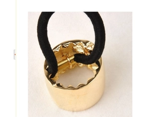 Detail of golden metal hair cuff showing inner hammered texture and elastic band