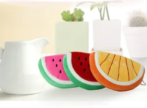 Close-up of watermelon and orange plush coin purses with detailed embroidery and zippers