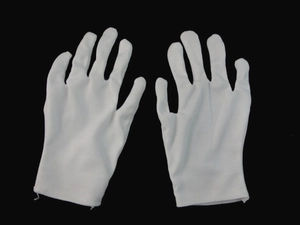 Detailed top view of white cotton magician gloves showing fabric texture on black background