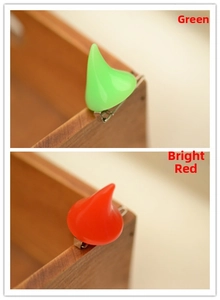 Detailed view of neon resin devil horn hair clips in vibrant green and red colors