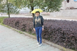 Detailed view of a yellow hands-free umbrella hat worn outdoor for fishing or sun protection