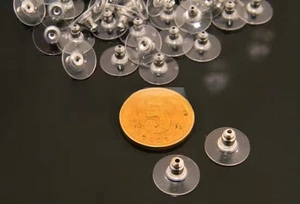 Macro detail of metal bullet earring backs with clear plastic pads for jewelry making