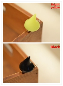 Detail shot of yellow and black resin devil horn hair clips with glossy finish