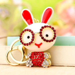 Detailed close-up of a white rabbit keychain with red rhinestone inlay and gold metal chain