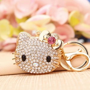 Close-up of sparkling rhinestone Hello Kitty high-heeled shoe keychain on wood