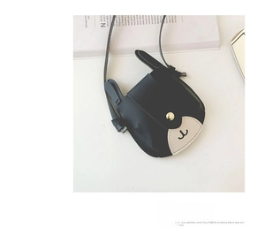 Close-up of animal-shaped crossbody bag in black and white leather with a gold buckle