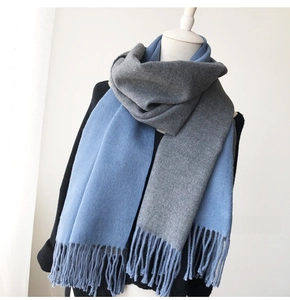 Detail of blue and grey patchwork cashmere-like scarf with tassels on a mannequin