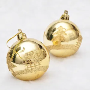 Set of two gold 6cm Christmas balls with glitter cedar patterns on white plush background