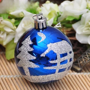 Detail of blue Christmas ball featuring silver glitter patterns of trees and stars