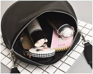 Interior view of black crescent crossbody bag showing capacity for cosmetics and accessories