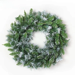 Detail of green artificial Christmas wreath with white flocked snow effect on pine needles