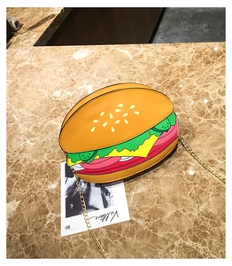 Detail of creative burger-shaped crossbody bag with vibrant layers and golden chain strap