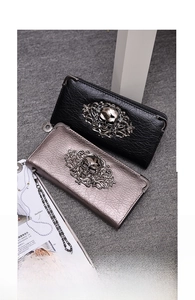 Detail of punk style long skull wallets with gothic metal ornaments and pebble leather