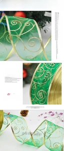 Detail of green organza Christmas ribbon with golden glitter swirls and wired edges