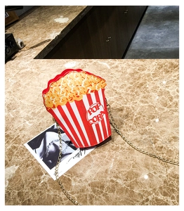 Detail of creative popcorn shaped shoulder bag with red stripes and metal chain strap