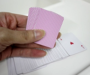 Close-up of mini playing cards featuring pink polka dot pattern and Ace of Hearts card