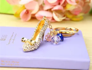 Close-up of rhinestone high heel keychain with three colored crystal beads on purple diary