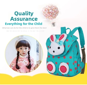 Close-up of green polka dot kids backpack featuring a 3D bunny design and plush ears