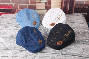 Flat lay of vintage striped baby newsboy caps in light blue, white, navy, and black
