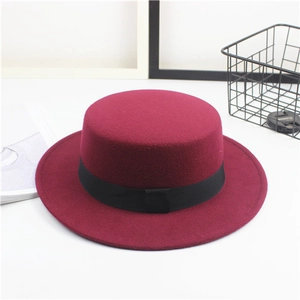Detail of burgundy wool felt flat top boater hat with a minimalist black ribbon band