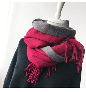 Close-up of thick bicolor cashmere-feel scarf in rose red and charcoal gray with tassels