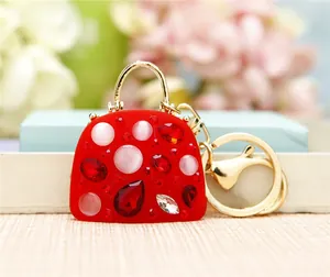 Macro shot of red handbag keychain pendant with sparkling zircons and gold ring