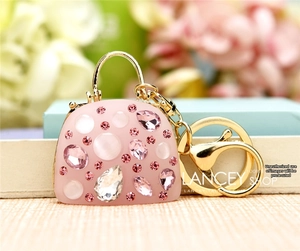Macro detail of pink handbag keychain with glittering rhinestones and gold lobster clasp