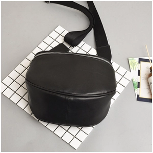 Detail of minimalist black PU leather crescent crossbody bag with silver zipper