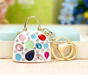 Macro shot of handbag-shaped keychain with colorful rhinestones and gold metal finish