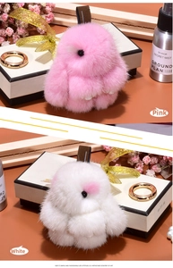 Detail of pink and white plush mink fur rabbit charms with gold hooks and woven straps