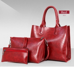 Three-piece red synthetic leather handbag set including a large tote and shoulder bags